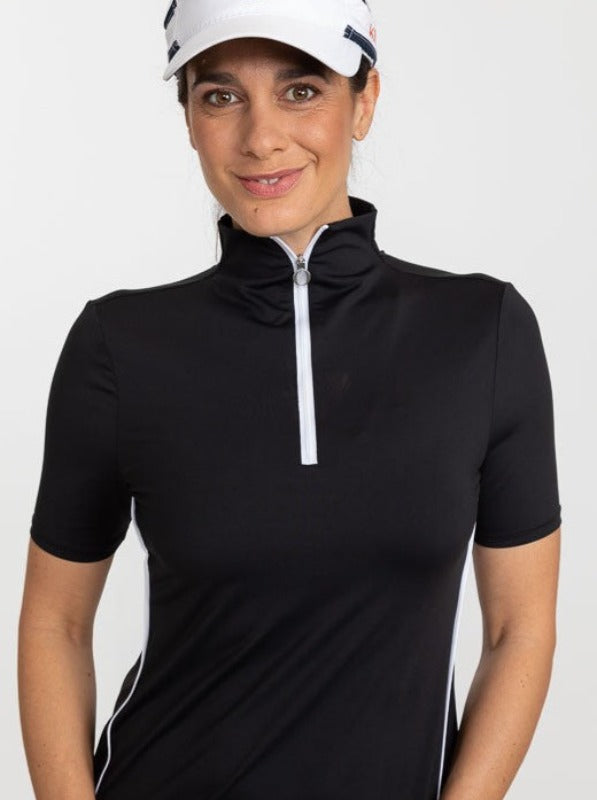 Front view of a woman wearing a white No Hat Hair Visor and a Keep It Covered Short Sleeve Golf Top in black