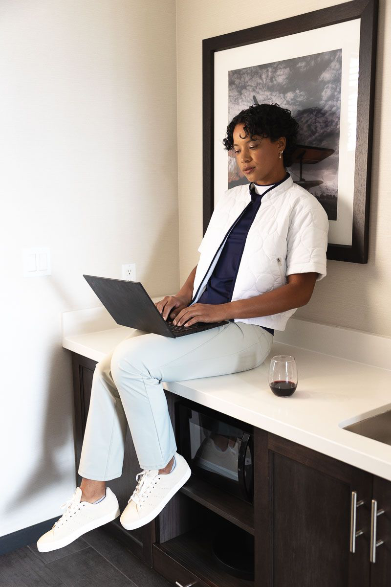  A woman wearing a white shirt, a pair of long pants, and a white pair of shoes 