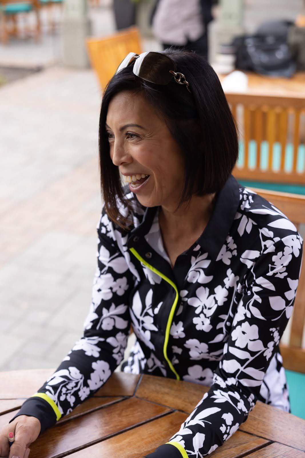 A woman wearing a chartreuse, black, and white long-sleeved shirt