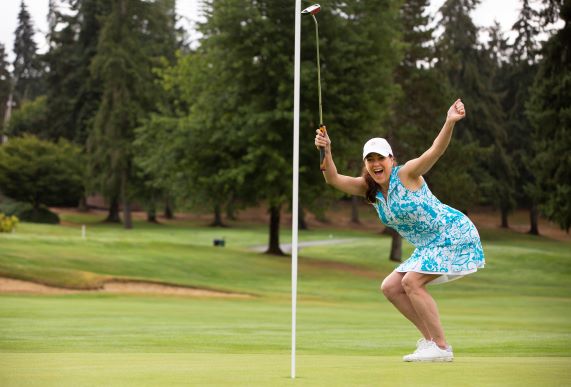 A happy woman playing golf