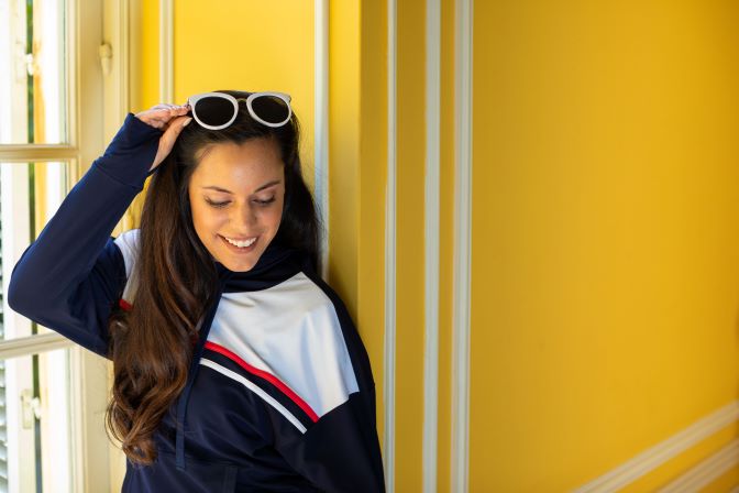  A woman smiling and putting on sunglasses