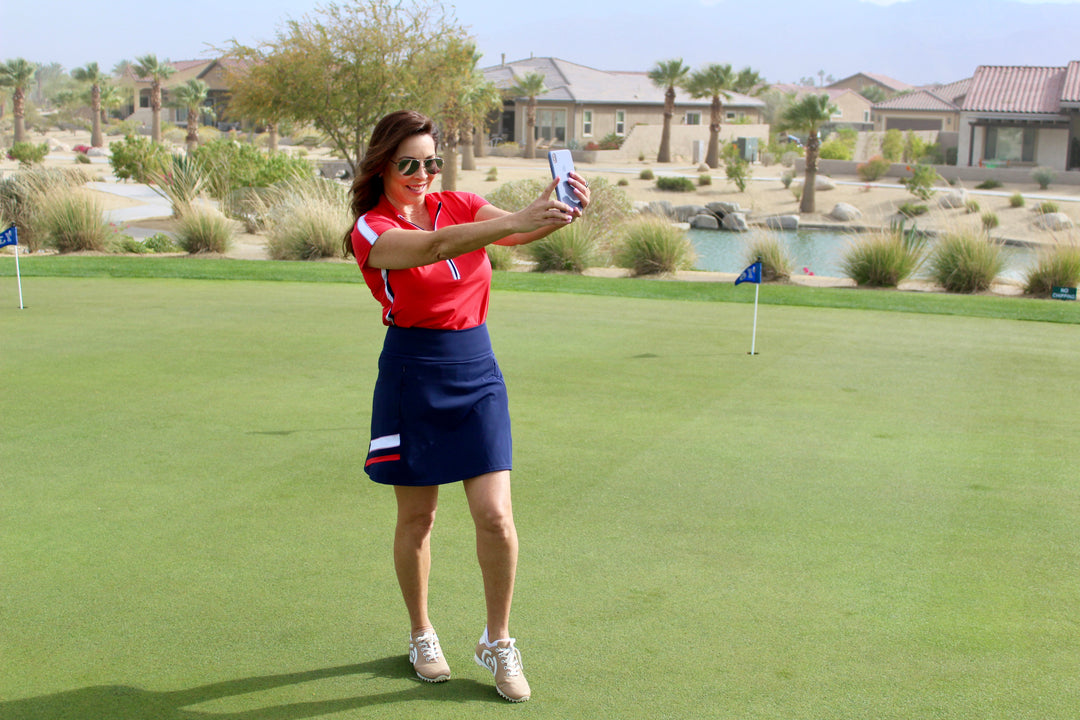 A woman wearing a red top and navy blue skirt