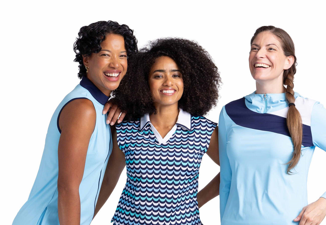 Three women smiling in coordinating outfits