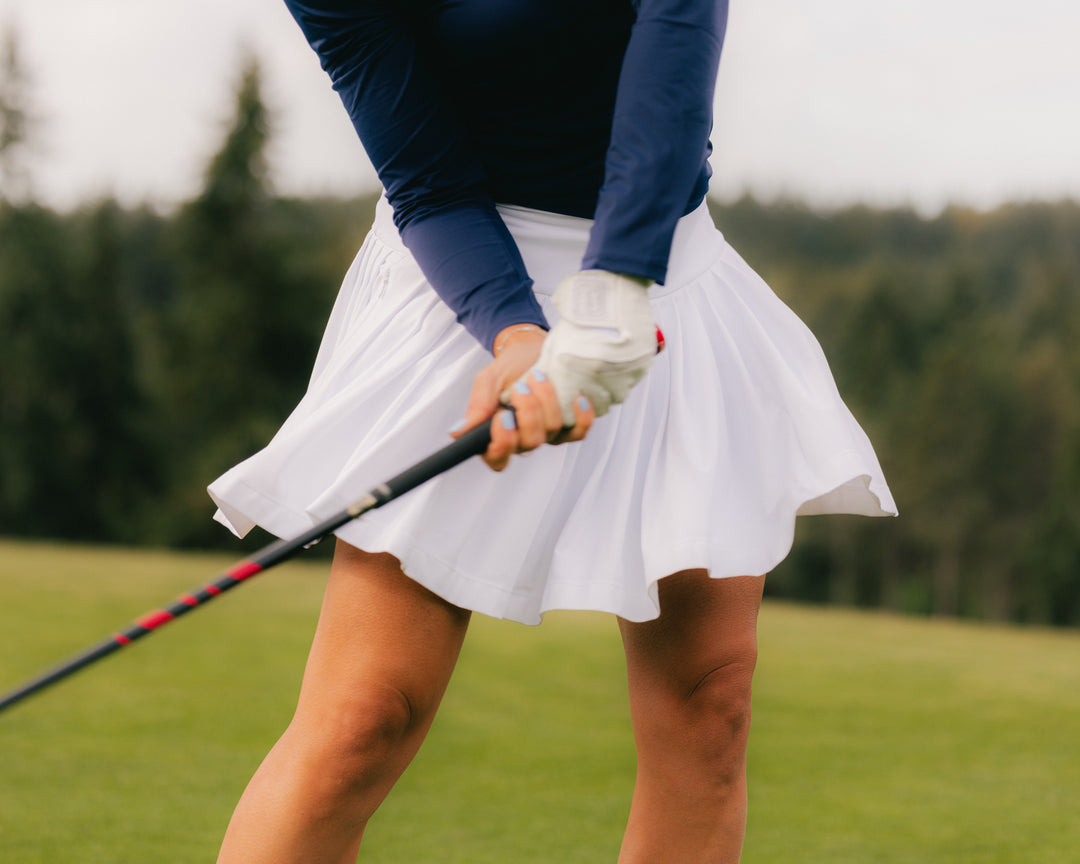 women golfing wearing a white golf skort