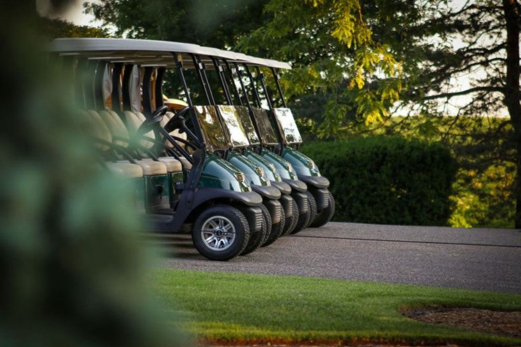 A row of golf carts lined up at the course