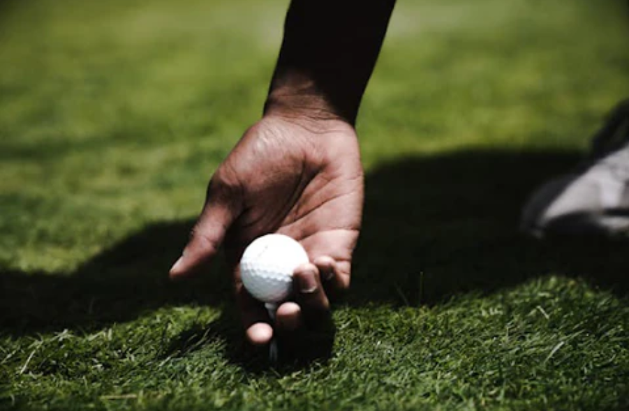 A hand grabbing a golf ball