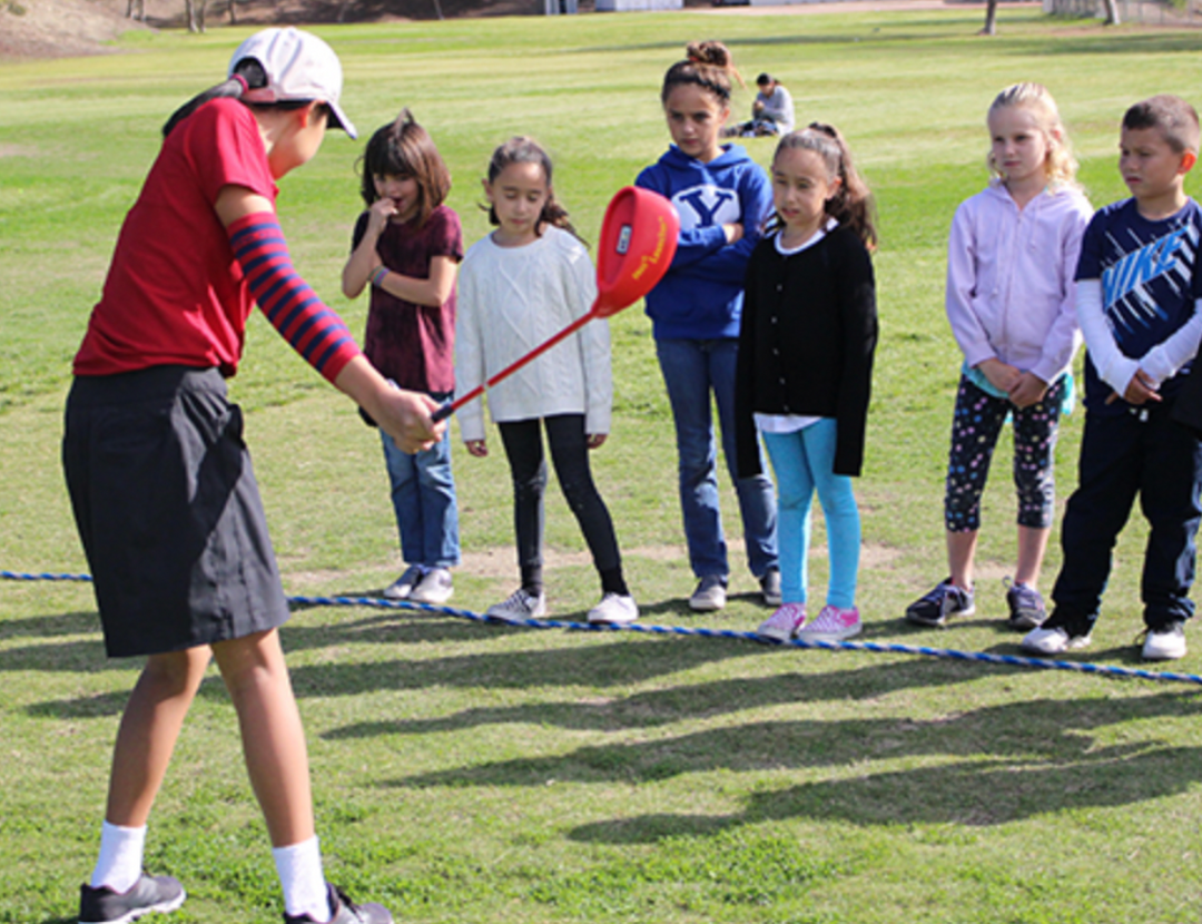 Vanessa Ngo volunteering and teaching a group of junior golfers.