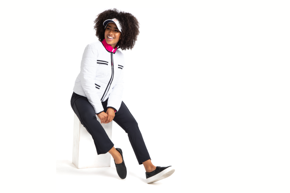 A female golf model in KINONA's Polished for Play jacket in white.
