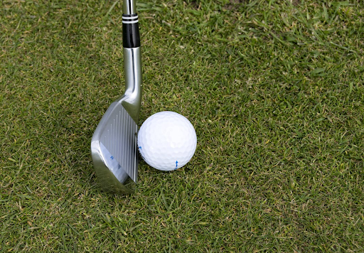 A golf ball and club on an at home practice area