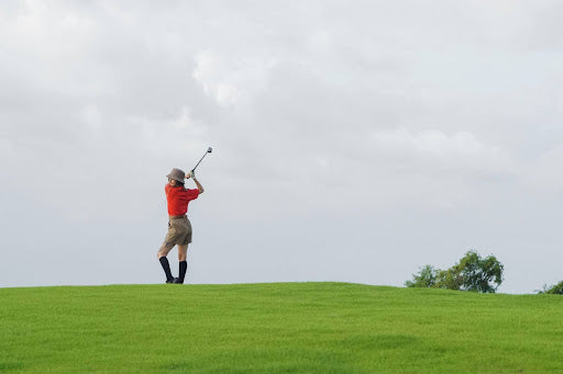 Woman Swinging Golf Club