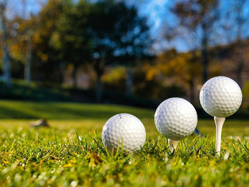 Golf Balls Lined up on Tees