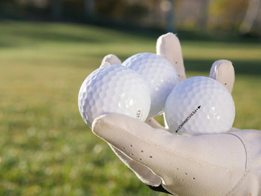 A hand holding golf balls