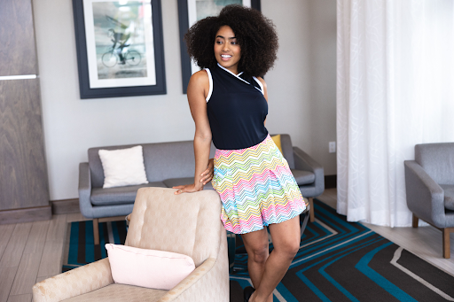 A woman wearing athleisure wear, leaning on a chair