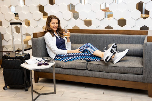 woman sitting in a lounge area with luggage