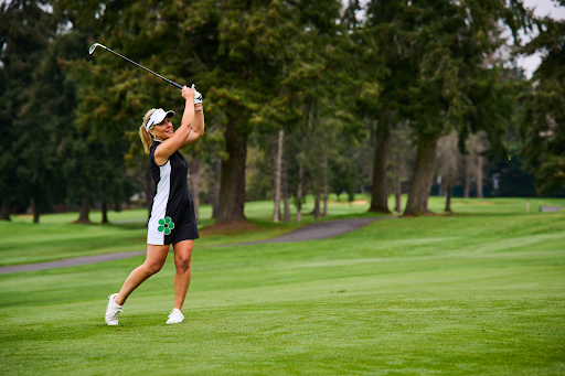 A woman swinging a golf club 