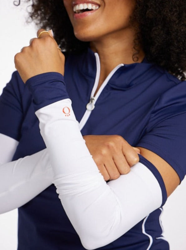 Woman with arms crossed in front of her wearing a pair of Sun's Out Golf Sleeves in navy blue.  Women's golf sun protection, UPF 50+.