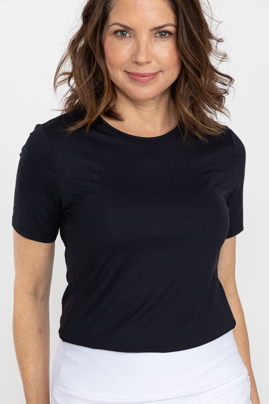 Front view of a woman wearing a Tee It Up Short Sleeve Golf Shirt in black