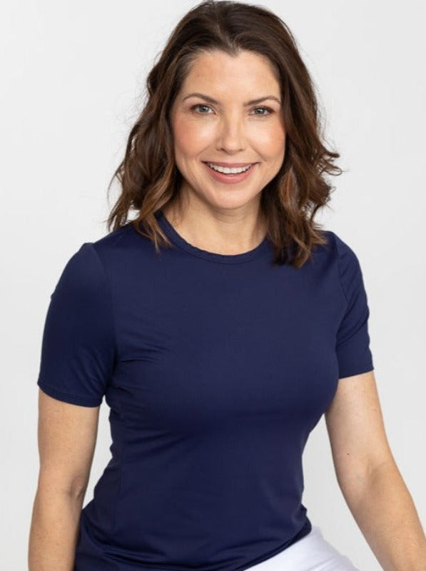 Front view of a woman wearing a Tee It Up Short Sleeve Golf Shirt in navy blue