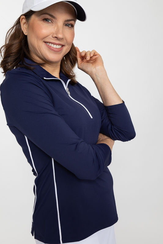 Side view of a smiling woman wearing a white We've Got You Covered Hat and a Keep It Covered Long Sleeve Golf Top in navy blue