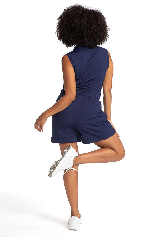 Full back view of a woman wearing the Style For Miles Golf Romper in navy blue