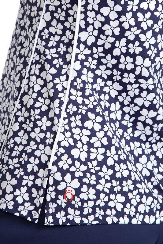 Close view of the hemline on the Keep It Covered Sleeveless Golf Top in Vinca Print. The Vinca print has a navy blue background with white flowers on it.