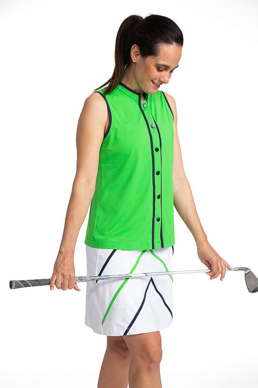 Full front and right side view of a woman wearing the Looking Snappy Sleeveless Golf Top in Fairway Green and the Show Me The Way Golf Skort in White (this skort has navy blue and fairway green accents). This top has Navy Blue accents around the collar an