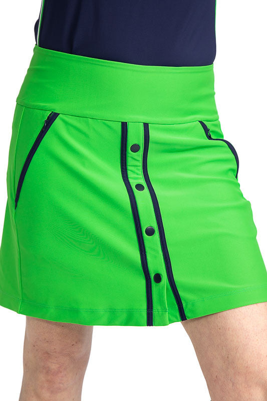Close front view of the Putt and Paddle Golf Skort in Fairway Green. This skort has navy blue accents on the front of the skort on either side of the snaps on the front and on each pocket.