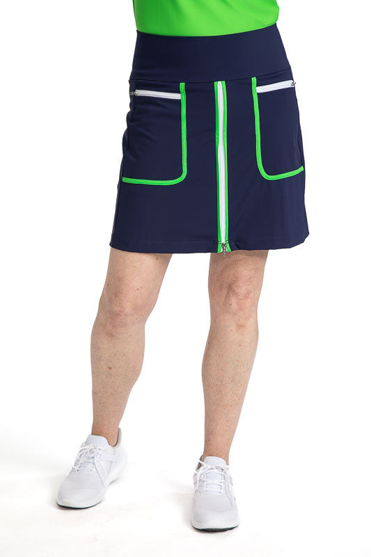 Front view of the Ready Play Golf Skort in Navy Blue. This golf skort also has Fairway Green accents down the length of the zipper on both sides, a white front zipper, Fairway Green curved L-shape accents around each pocket, and white horizontal zippers o