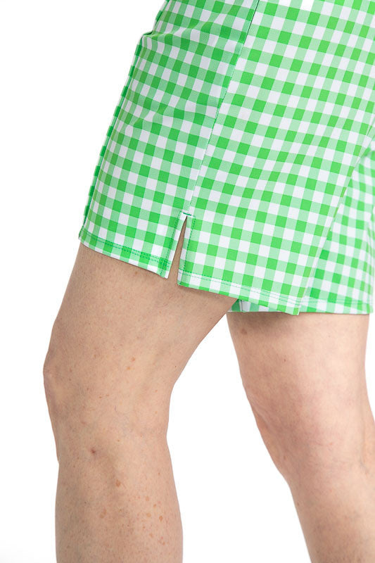 Close left side view of the hemline on the Tailored and Trim Golf Shorts in Go Go Gingham. The Go Go Gingham print is a green and white checkered print.