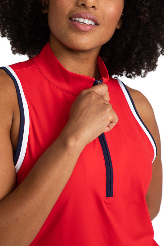 Close front view of the Love the Sun Sleeveless Golf Top in Cherry Red. This top has navy blue and white accents around the sleeve and navy blue on either side of the front zipper.