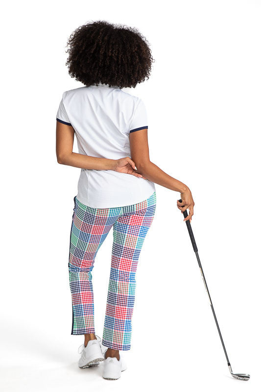 Complete back view of a woman wearing the Cute and Classic Short Sleeve Golf Top in White and the Smooth Your Waist Crop Pants in Vacation Plaid. This top also has accents of Fairway Green across the top of each shoulder and across the top of the left fro