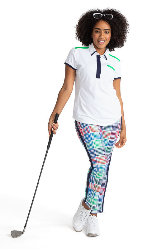 Complete front view of a smiling woman wearing Cute and Classic Short Sleeve Golf Top in White and the Smooth Your Waist Crop Pants in Vacation Plaid. This top also has accents of Fairway Green across the top of each shoulder and across the top of the lef