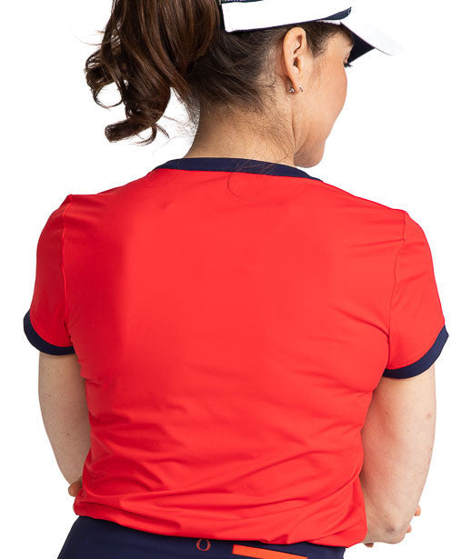 Back view of the Approach Shot Short Sleeve Golf Top in Cherry Red. This top has navy blue accents around each arm, the neckline, and the buttons on the front. The front is also accented with Workin' It Stripe across the top of each shoulder and behind th