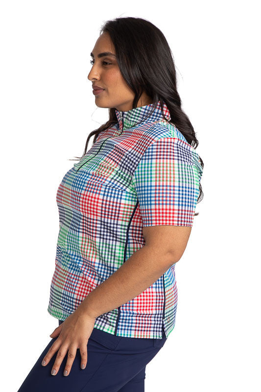 Close left side view of the Keep It Covered Short Sleeve Golf Top in Vacation Plaid. Vacation Plaid consists of a small, checkered pattern of red, blue, green and white.