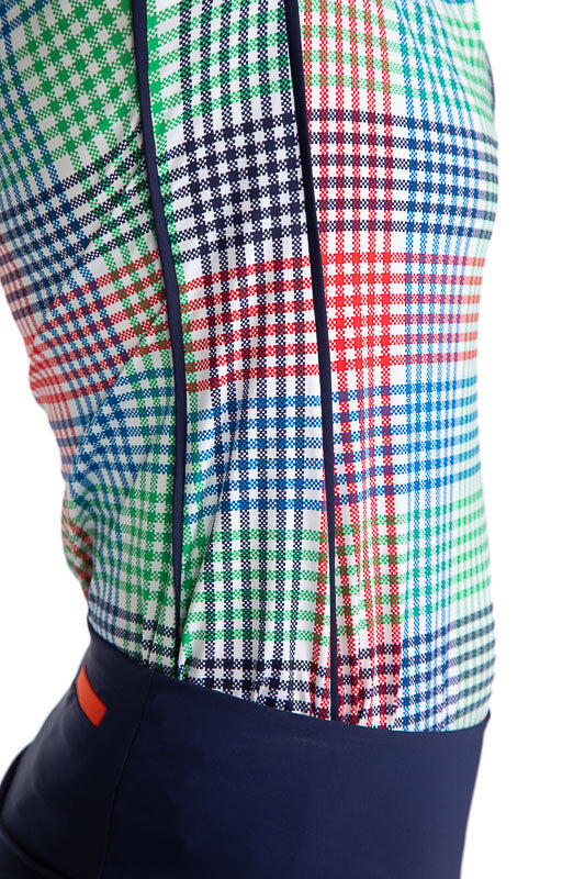 Close Right side view of the Keep It Covered Short Sleeve Golf Top in Vacation Plaid.  There are two solid navy blue stripes on either side of this top. Vacation Plaid consists of a small, checkered pattern of red, blue, green and white.