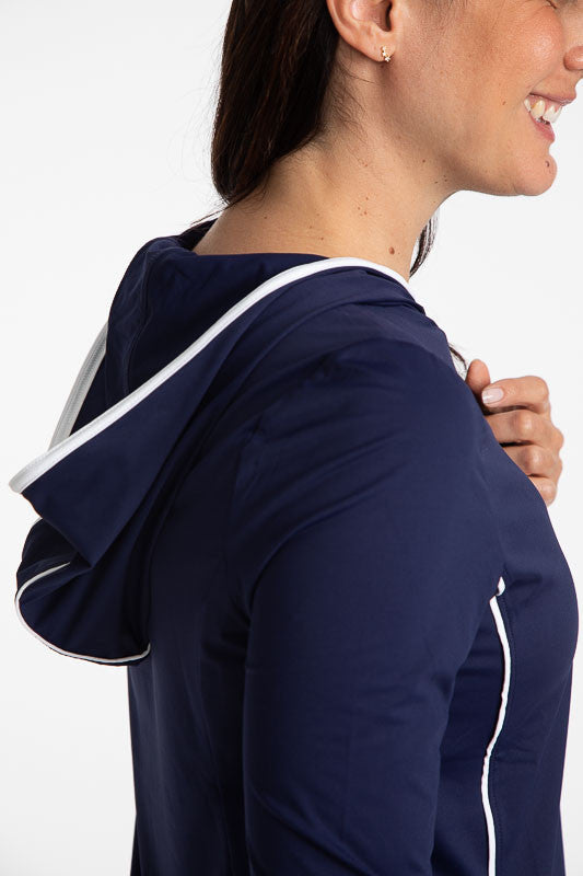 Close right side view of the Layer It Up Long Sleeve Hoodie Golf Top in Navy Blue. There are white accents around the edge of the hood and down each side of this hoodie.