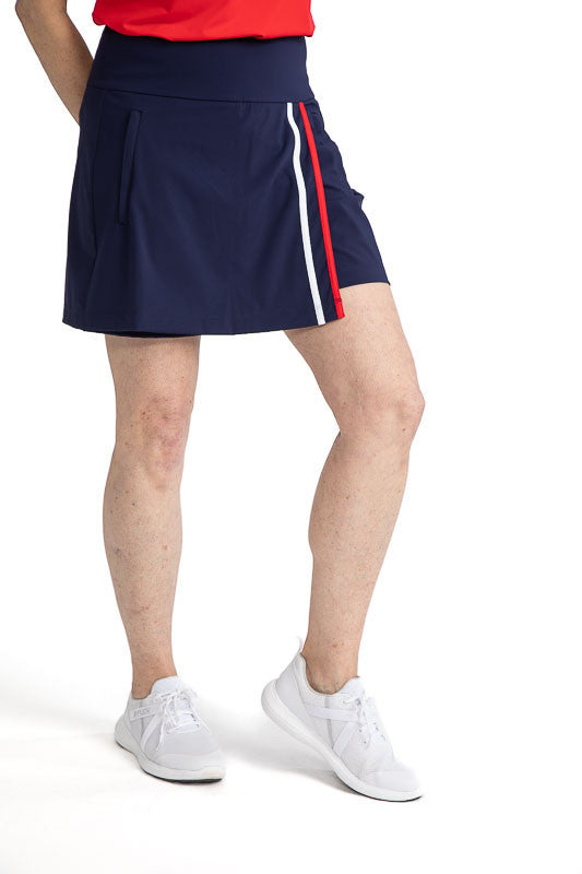 Front view of the Skort and Short Golf Skort in Navy Blue. This skort has two vertical stripes down the front left side in white and cherry red. 