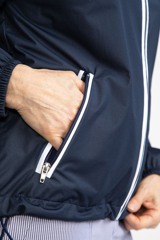Tight right side view of the pocket on the Pack and Play Lightweight Golf Jacket in Navy Blue. This jacket folds into a pouch that easily fits in your golf bag.