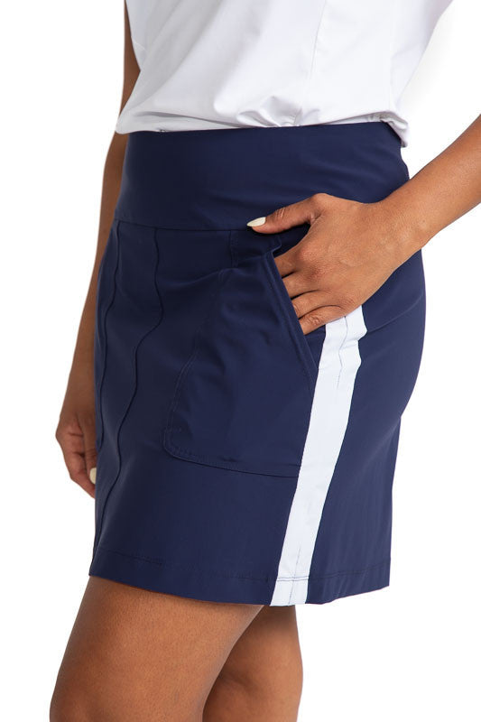 Close left side view of the stripe and pocket on the Pocket Envy Golf Skort in Navy Blue/White. This skort has one large white vertical stripe down each side of the skort. 