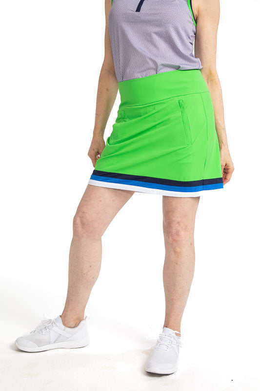 Front view of the On the Fringe Golf Skort in Fairway Green. This skort has three stripes around the bottom of this skort in Navy Blue, Azure Blue, and White. 
