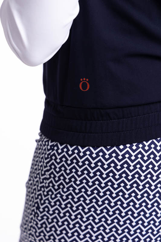 Close left side view of the waistband on the Fall Ball Golf Vest in Navy Blue. This is a solid navy blue vest with a white front zipper and elastic waistband.