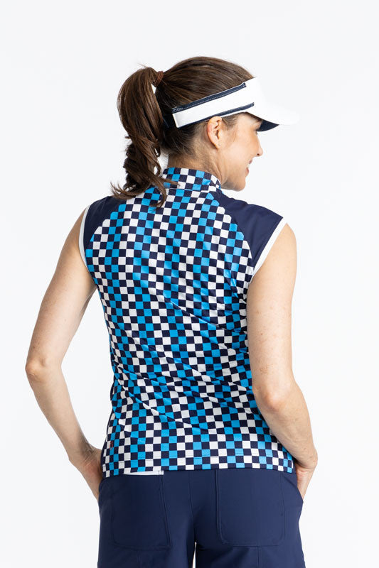 Back view of a woman wearing the No Hat Hair Visor in White and the Cap to Tap Short Sleeve Golf Top in Check It Out Print. This print is a mix of French blue, black, and white checks forming a vertical striped pattern. This top features cap sleeves that 