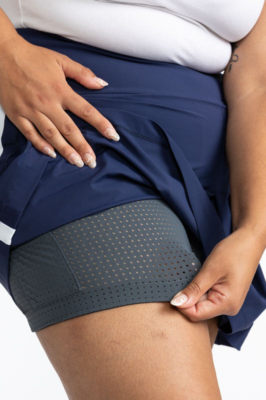 Close left side view of the medium grey shortie on the Party Pleat Golf Skort in Navy Blue