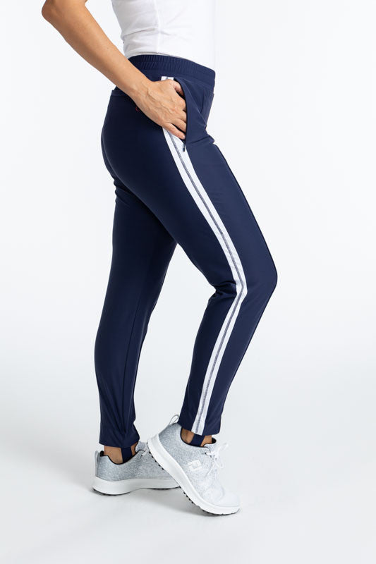 Right side view of the Ankle Warmer Stirrup Pants in Navy Blue. These pants have a white stripe that runs down each side of the pants.