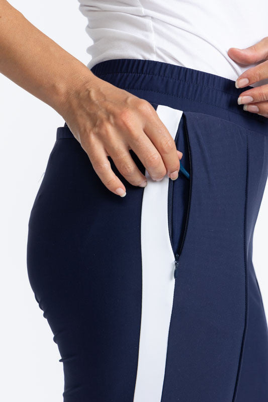 Close right side view of the pocket on the Ankle Warmer Stirrup Pants in Navy Blue. These pants have a white stripe that runs down each side of the pants.