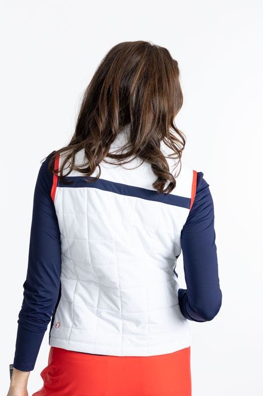 Back view of the Chill Layer Golf Vest in White. This vest is primarily white, with a solid, horizontal navy blue stripe across the front and back of this vest. There are also tomato red accents on either side of the zipper on the front and around each ar