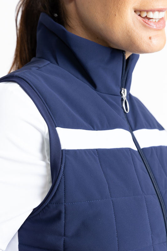 Close right side and front view of the neckline on the Chill Layer Golf Vest in Navy Blue. In this view, you can see the solid, horizontal white stripe that runs across the front of this vest just above the chest.