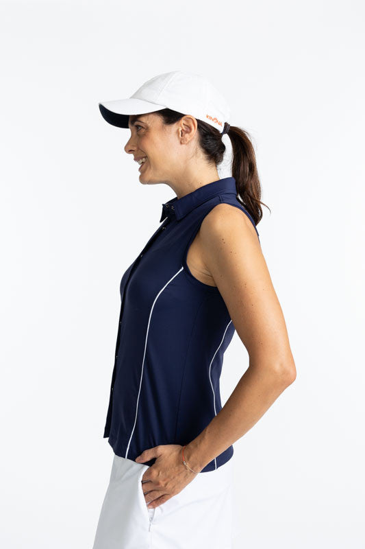 Left side view of the Dew Sweeper Sleeveless Golf Top in Navy Blue and the We've Got You Covered Hat in White