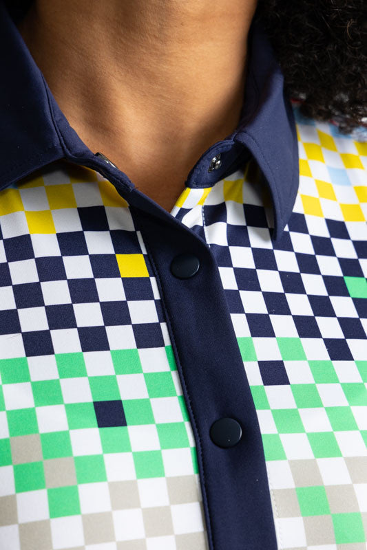Close front view of the neckline on the Dew Sweeper Sleeveless Golf Top in Cheeky Check Print. This print is made up of a checked horizontal patter that creates a horizontal wrap in black, grass green, lemon yellow, French blue, and tomato red on a white 
