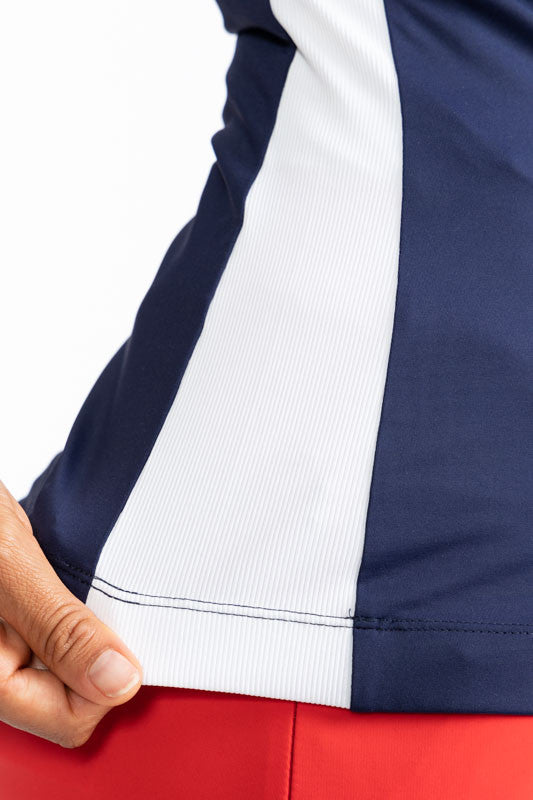 Close right side view of the hemline on the Winter Rules Long Sleeve Golf Top in Navy Blue. In this view, you can see the white, solid stripe that runs down each side of this top.